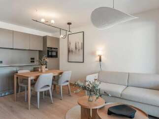Experience modern living in this beautifully appointed apartment, featuring a sleek, integrated kitchen with ample cabinet space and a stylish dining area perfect for intimate meals.