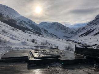 Experience the ultimate winter retreat with this stunning property featuring an outdoor hot tub nestled amidst breathtaking snow-capped mountains.