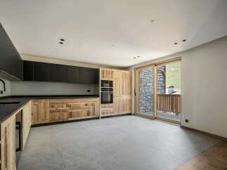 Experience modern mountain living in this stunning kitchen featuring sleek black cabinetry contrasted with rustic wooden lower cabinets and countertops.