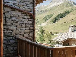 Experience the charm of mountain living with this stunning property, featuring rustic stone architecture and warm wooden accents.