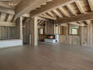 Experience rustic luxury in this stunning wooden chalet, featuring exposed beams and a cozy fireplace.