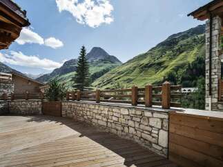 Experience breathtaking mountain views from this stunning property, featuring a spacious wooden deck perfect for outdoor relaxation.