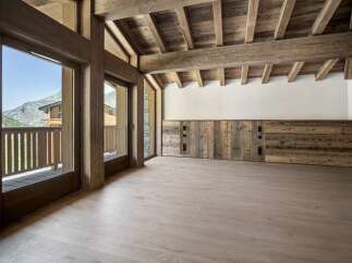 Experience luxurious mountain living in this stunning property featuring expansive wooden beams and a vaulted ceiling that creates an airy, open atmosphere.