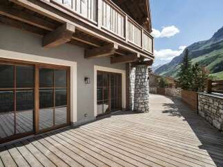 Experience luxury mountain living with this stunning property featuring expansive wooden decks and large glass doors that seamlessly blend indoor and outdoor spaces.