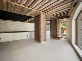 Experience rustic elegance in this stunning interior featuring exposed wooden beams and natural wood-clad columns.