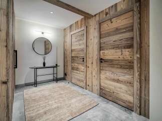 Step into a charming mountain retreat featuring rustic wooden doors and walls that exude warmth and character.