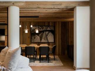 Experience luxury mountain living in this stunning dining area, featuring a warm wooden ceiling and walls that exude rustic charm.
