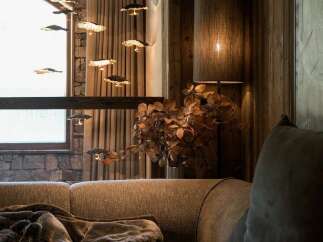 Experience rustic elegance in this cozy living space, featuring a plush sectional sofa adorned with a luxurious faux fur throw.