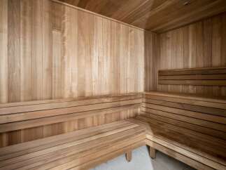 Experience ultimate relaxation in this luxurious sauna, featuring natural wood paneling and comfortable tiered seating.