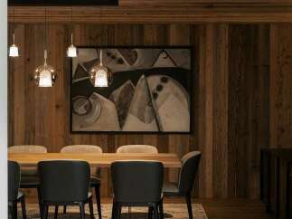Experience rustic elegance in this dining room, featuring warm wood-paneled walls and a coordinating wood-plank ceiling.