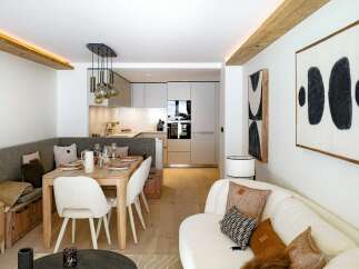 Experience modern living in this beautifully appointed apartment, featuring a sleek, integrated kitchen and a cozy dining nook with a built-in banquette.