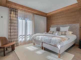 Experience ultimate comfort in this beautifully appointed bedroom, featuring a plush king-sized bed with crisp white linens and a cozy throw.