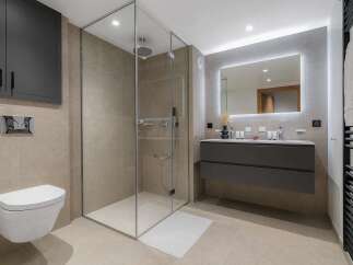 Experience modern luxury in this stunning bathroom featuring a spacious glass-enclosed shower and a sleek, wall-mounted vanity.