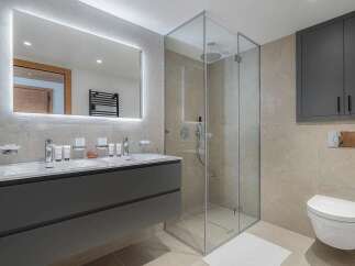 Experience modern luxury in this stunning bathroom, featuring a sleek double vanity with integrated lighting and ample storage.