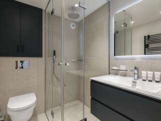 This modern bathroom features a sleek design with a floating vanity and a spacious glass-enclosed shower.