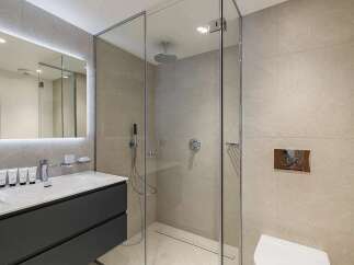 Experience modern luxury in this stunning bathroom, featuring a sleek vanity with a minimalist sink and a wall-mounted faucet.