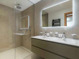 Experience modern luxury in this stunning bathroom featuring a spacious walk-in shower with a rainfall showerhead and elegant tiled walls.