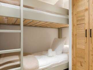 This cozy bedroom features a space-saving bunk bed, perfect for families or accommodating guests.