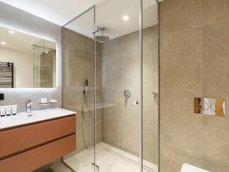 Experience modern luxury in this stunning bathroom featuring a sleek glass-enclosed shower with a rainfall showerhead and a convenient handheld wand.