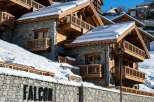 Experience luxury mountain living in this stunning chalet, featuring a stone facade and warm wooden accents.