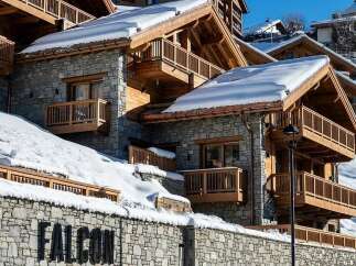 Experience luxury mountain living in this stunning chalet, featuring a stone facade and warm wooden accents.