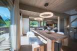 Experience luxurious mountain living in this stunning dining area, featuring a rustic wooden table and plush seating, perfect for intimate gatherings.