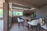 Experience modern mountain living in this stunning kitchen featuring sleek grey cabinetry and a spacious island with a marble countertop.