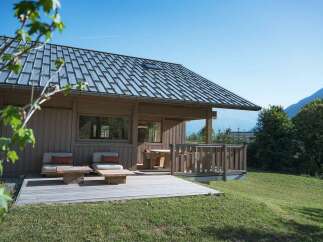 Experience serene mountain living in this charming wooden cabin, featuring a spacious deck perfect for enjoying the breathtaking alpine views.