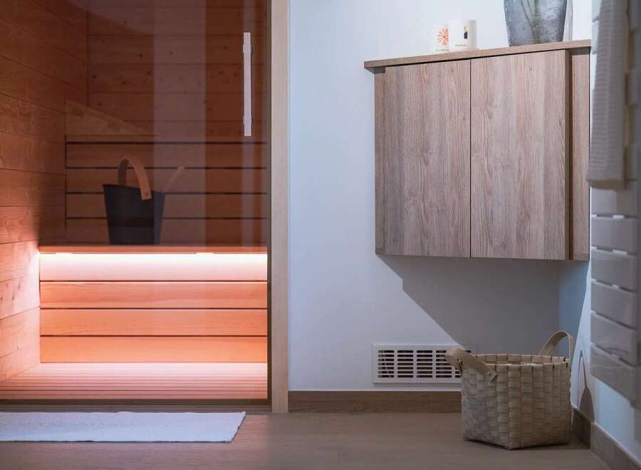 Experience ultimate relaxation in this modern sauna, featuring warm wood paneling and ambient lighting.