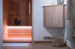 Experience ultimate relaxation in this modern sauna, featuring warm wood paneling and ambient lighting.
