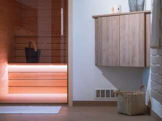 Experience ultimate relaxation in this modern sauna, featuring warm wood paneling and ambient lighting.