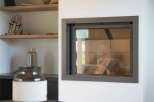 Experience modern living with this sleek fireplace, featuring a clean-lined design and a glass front that offers a view of the logs within.