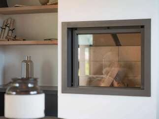 Experience modern living with this sleek fireplace, featuring a clean-lined design and a glass front that offers a view of the logs within.