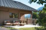 Experience serene mountain living in this charming wooden cabin, featuring a spacious deck with comfortable seating and a rustic wooden table, perfect for enjoying the breathtaking natural surroundings.