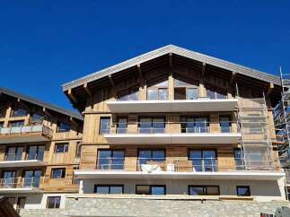 Discover this stunning new construction chalet, featuring a modern wooden facade and expansive balconies offering breathtaking mountain views.