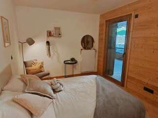 Experience cozy mountain living in this charming bedroom featuring a comfortable bed adorned with plush pillows and a soft grey throw.