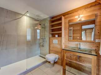 Experience modern comfort in this beautifully appointed bathroom, featuring a spacious glass-enclosed shower with sleek tilework and a convenient wall-mounted toilet.