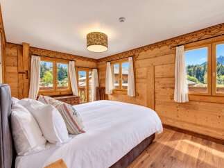Experience rustic charm and breathtaking mountain views in this beautifully appointed bedroom.