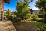 Step onto a charming wooden deck that leads to a lush green garden, perfect for outdoor relaxation.