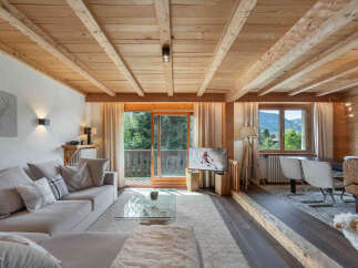 Experience the ultimate alpine retreat in this stunning living space, featuring exposed wooden beams and a cozy fireplace.