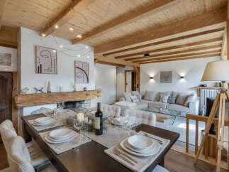 Experience rustic elegance in this charming dining and living area, featuring a beautifully set dining table perfect for intimate gatherings.