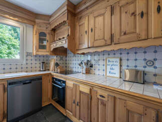This charming kitchen features rustic wooden cabinetry and a classic blue and white tiled backsplash.