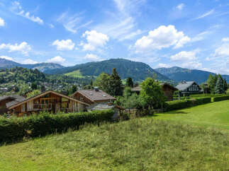 Experience the charm of alpine living in this picturesque village setting, nestled amidst rolling green hills and majestic mountains.
