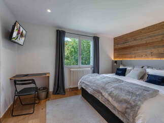 Experience cozy mountain living in this charming bedroom, featuring a rustic wooden accent wall that adds warmth and character.