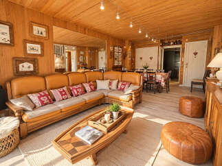 Experience rustic charm in this inviting living space, featuring a large, comfortable sectional sofa adorned with decorative pillows.