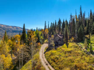 Nestled amidst a vibrant autumn forest, this unique home offers a secluded mountain retreat.