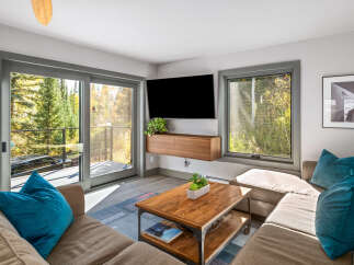 Experience cozy living in this inviting living room, featuring a plush sectional sofa adorned with vibrant teal pillows.