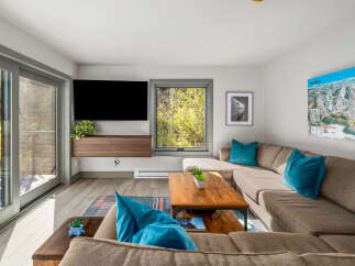 Experience modern living in this stylish living room, featuring a large sectional sofa perfect for gatherings and a wall-mounted TV for entertainment.