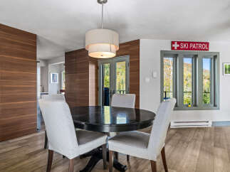 This dining area features a round, dark wood table surrounded by upholstered chairs, perfect for intimate gatherings.