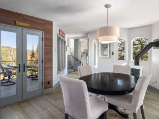 Enjoy breathtaking mountain views from this dining area, complete with a stylish black oval dining table and upholstered chairs.